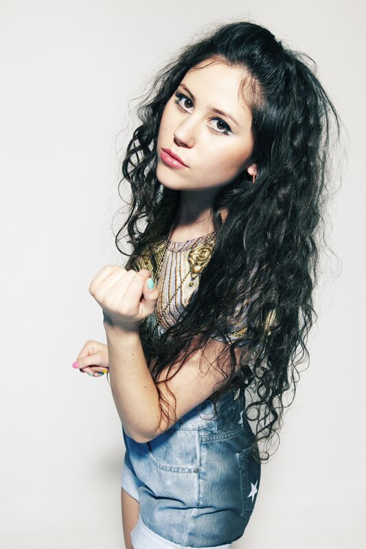 woman with curly hair in denim overalls