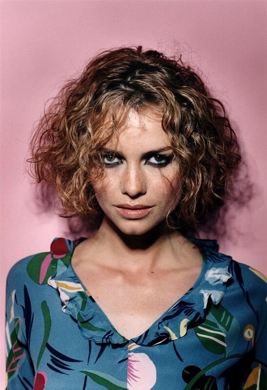 woman with curly hair in floral shirt