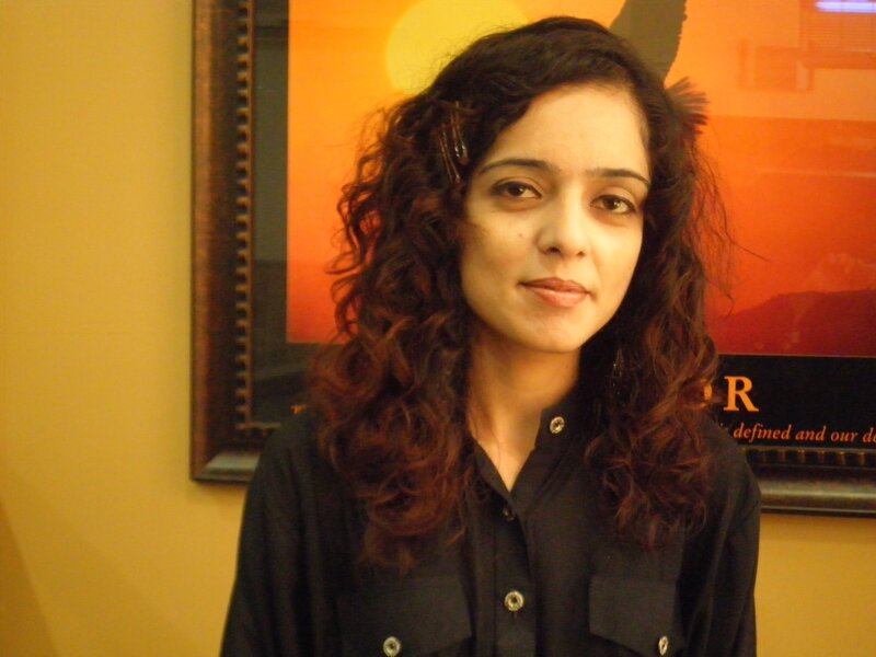 woman with curly hair in front of poster