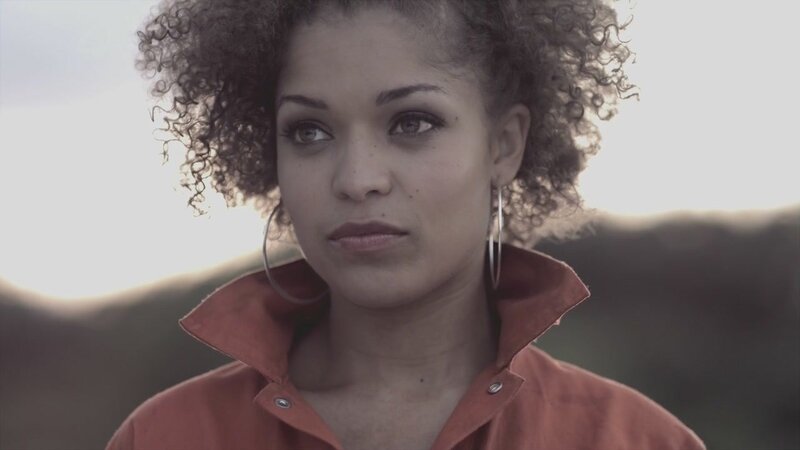 woman with curly hair in orange shirt