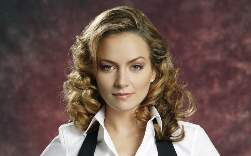 woman with curly hair in white shirt