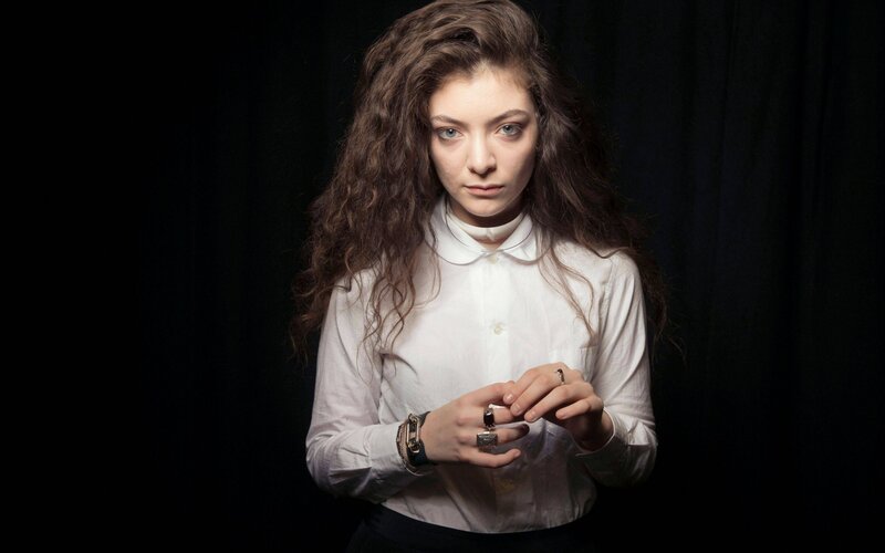 woman with curly hair in white shirt