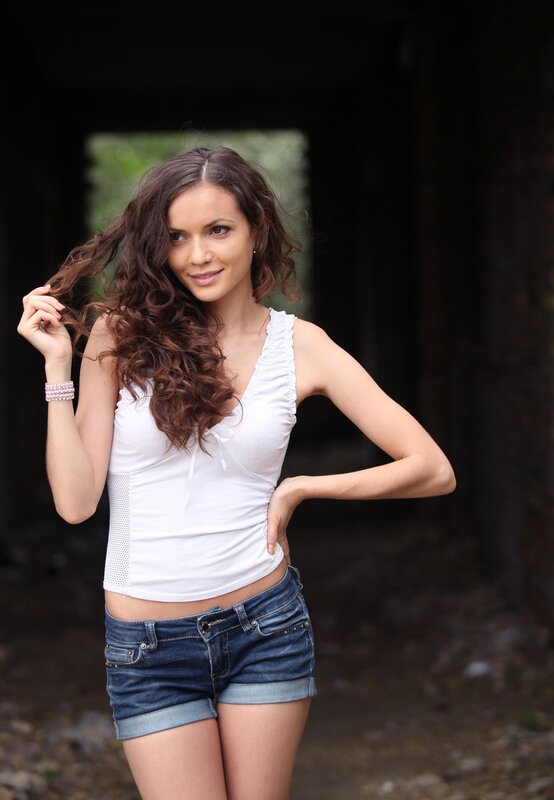 woman with curly hair in white top