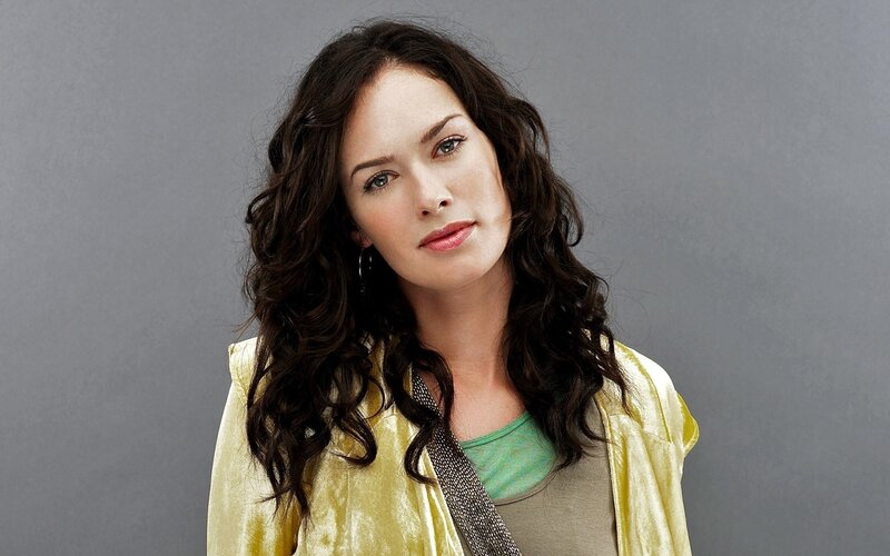 woman with curly hair in yellow jacket