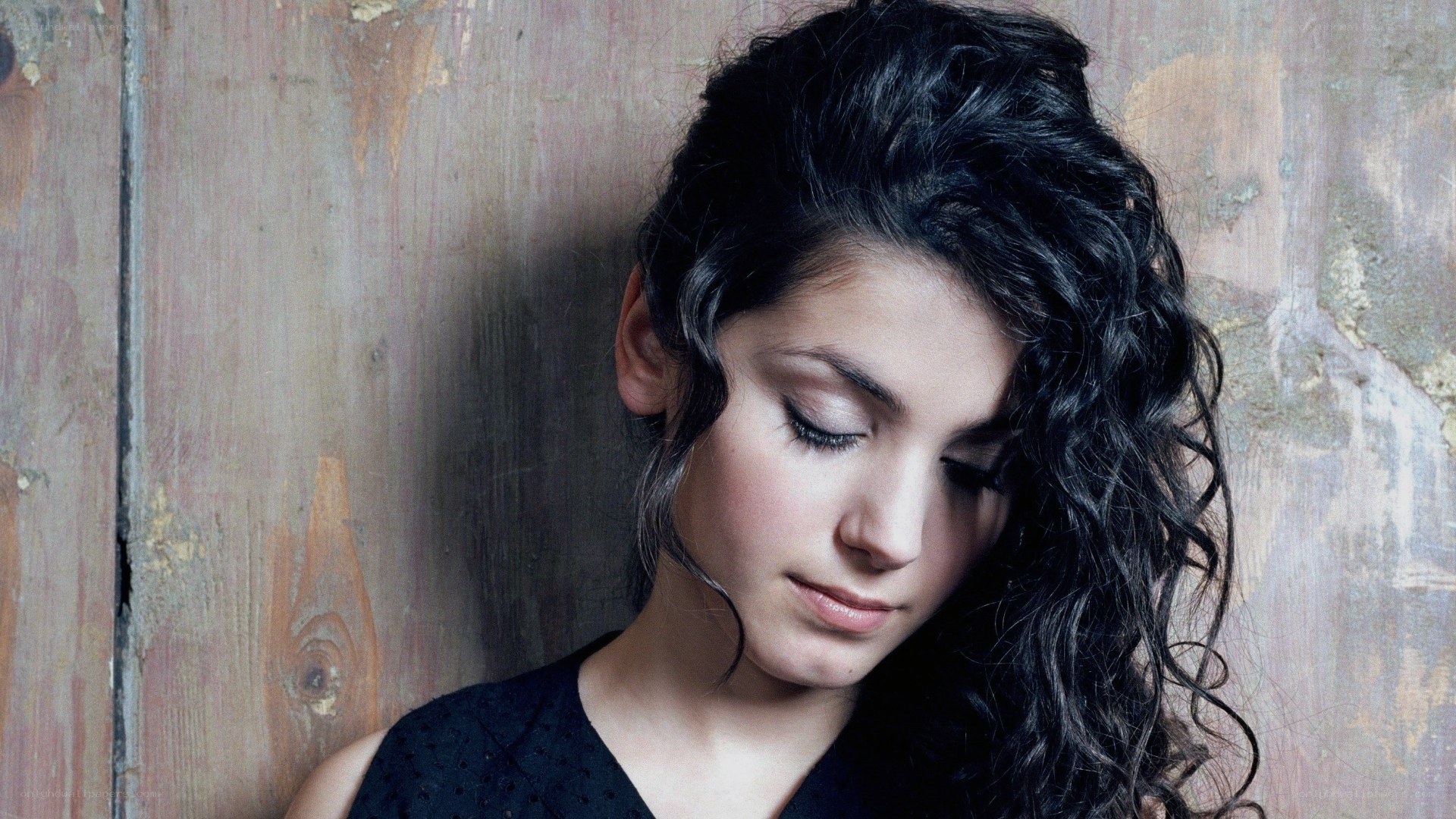 woman with curly hair leaning