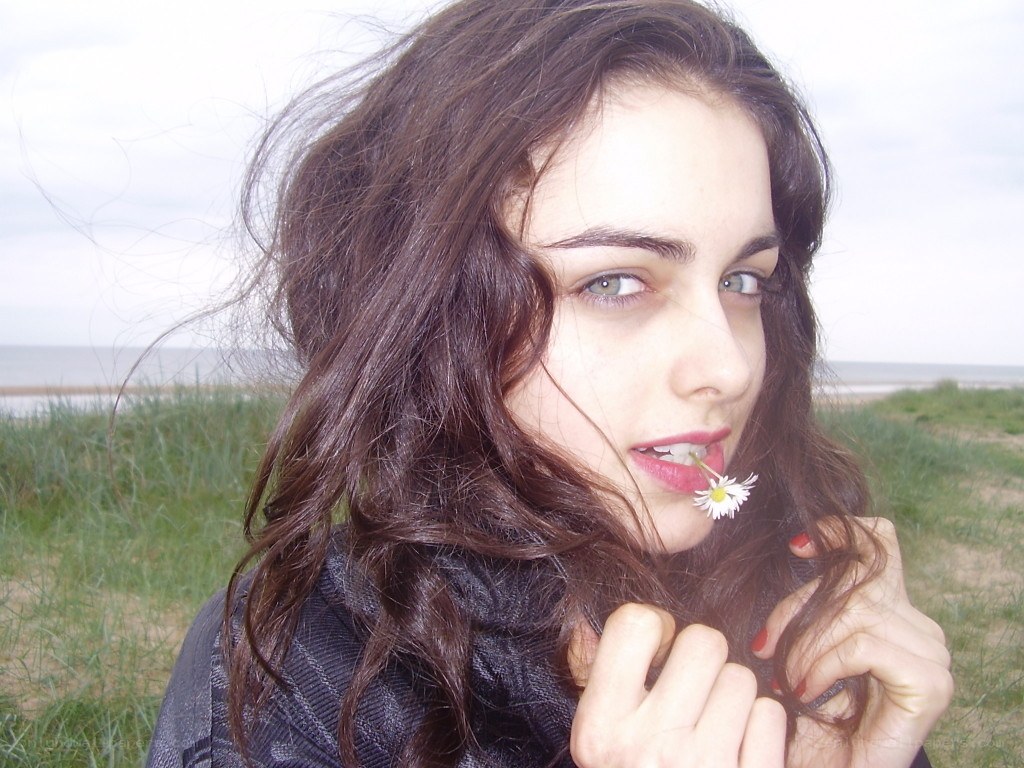 woman with daisy at beach