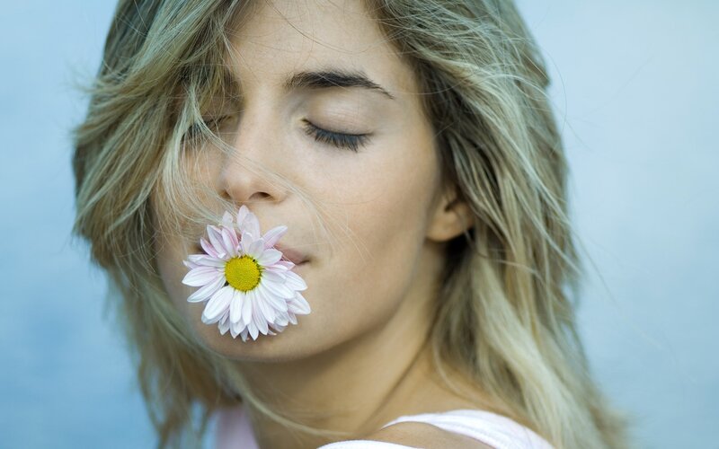 woman with daisy in her mouth