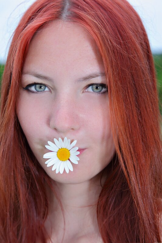 Woman with daisy in her mouth