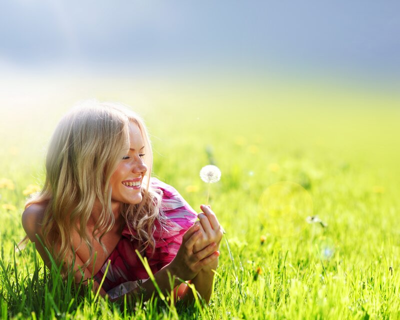 Woman with dandelion in field