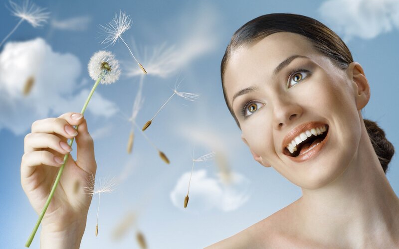 woman with dandelion in sky