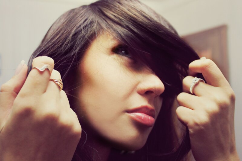 woman with dark hair adjusting her hair