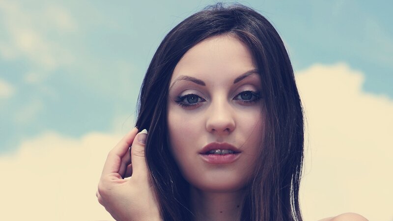 woman with dark hair against sky