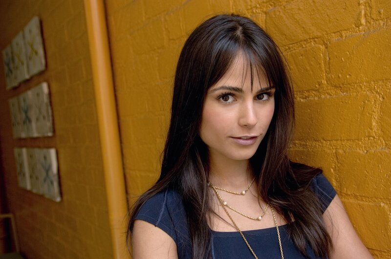 woman with dark hair against yellow wall
