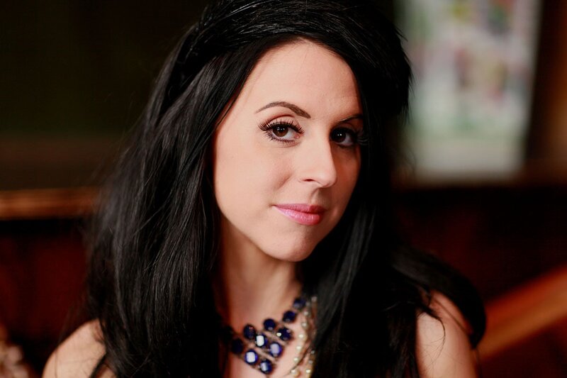 woman with dark hair and blue necklace