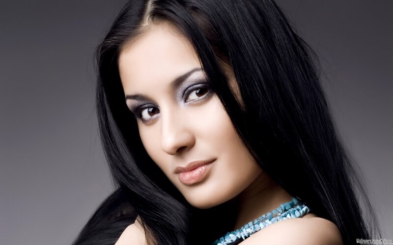 woman with dark hair and blue necklace