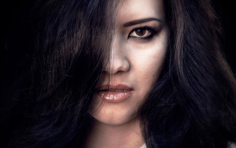 woman with dark hair and dramatic makeup