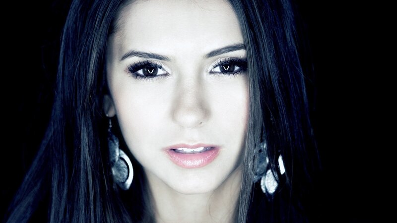 woman with dark hair and earrings