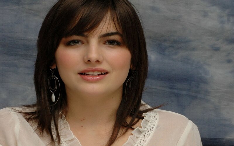 woman with dark hair and earrings