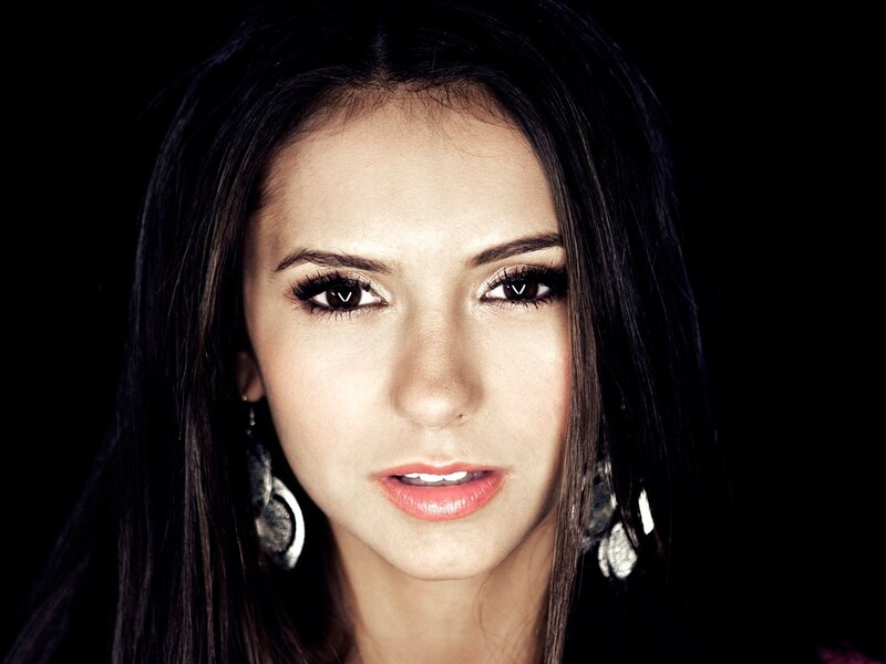 woman with dark hair and earrings