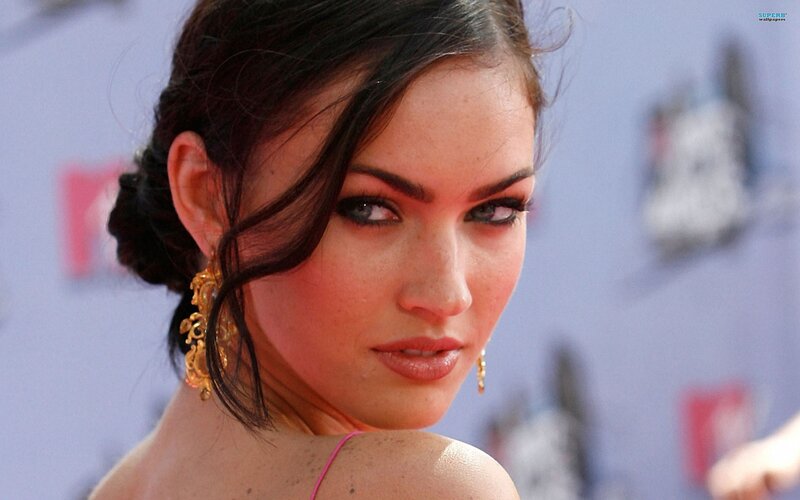 woman with dark hair and gold earrings