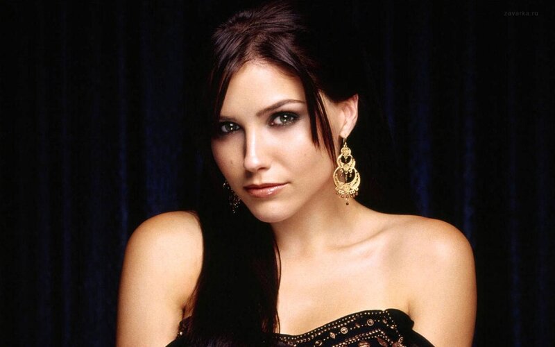 woman with dark hair and gold earrings