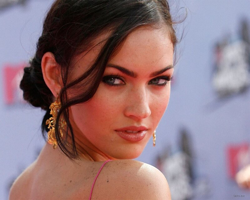 woman with dark hair and gold earrings