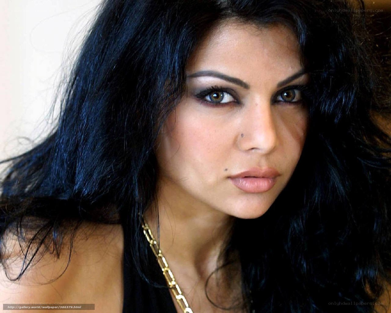 woman with dark hair and gold necklace