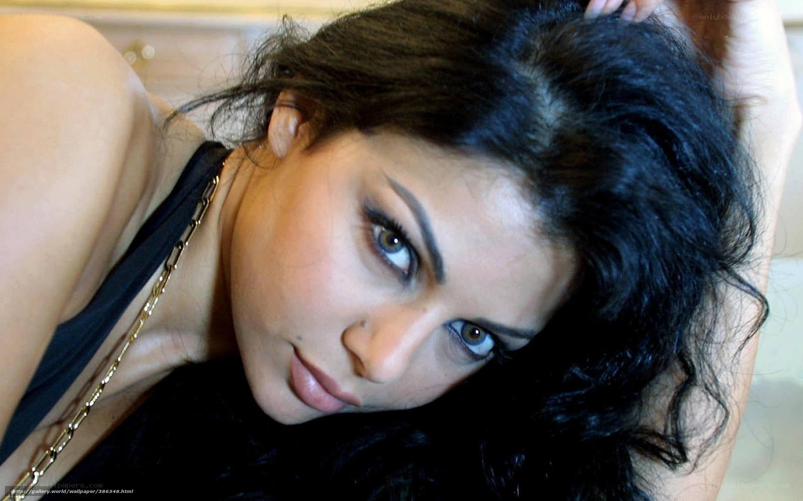 woman with dark hair and gold necklace