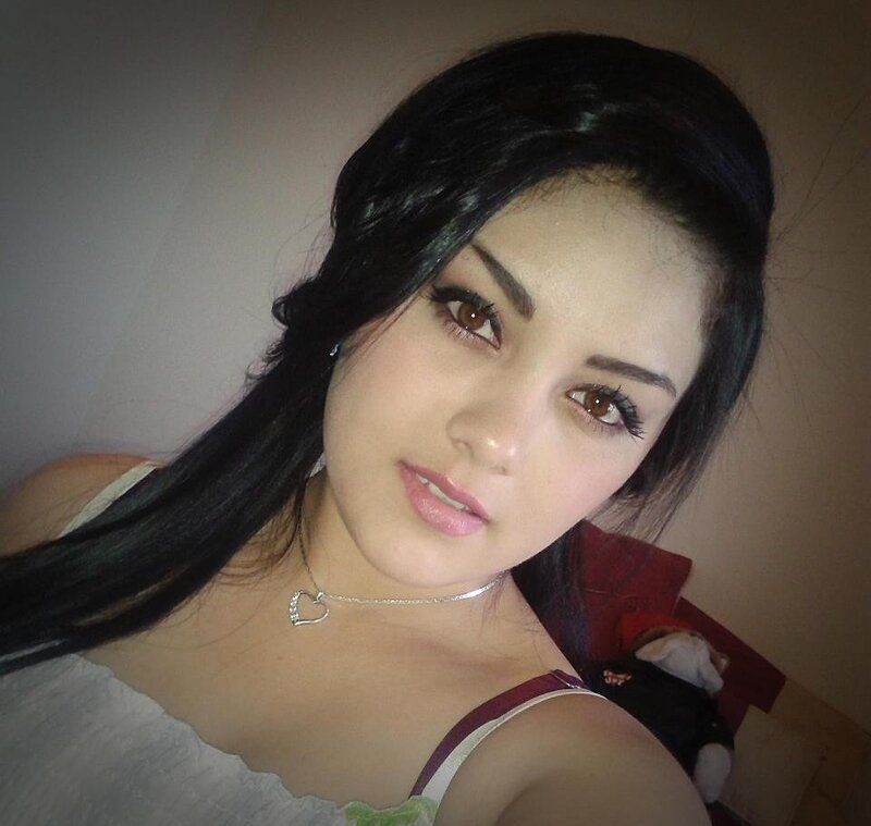 woman with dark hair and heart necklace