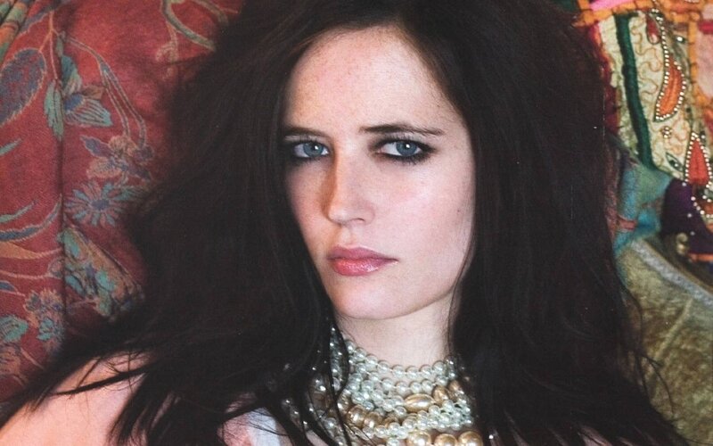 woman with dark hair and pearls