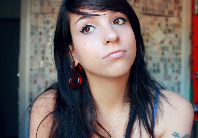 woman with dark hair and red earrings