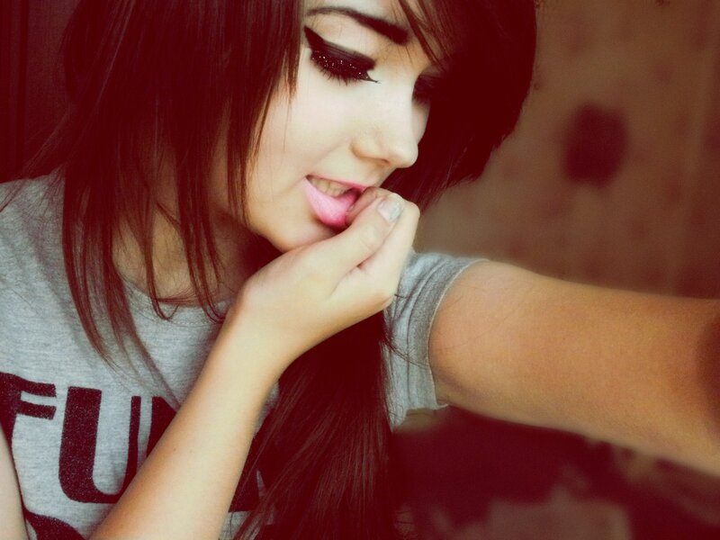 woman with dark hair biting lip
