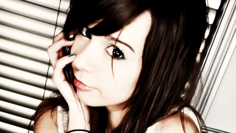 woman with dark hair by blinds
