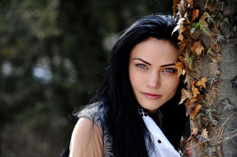 woman with dark hair by tree