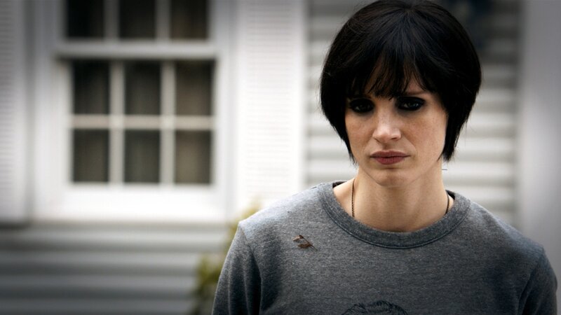 woman with dark hair in front of house