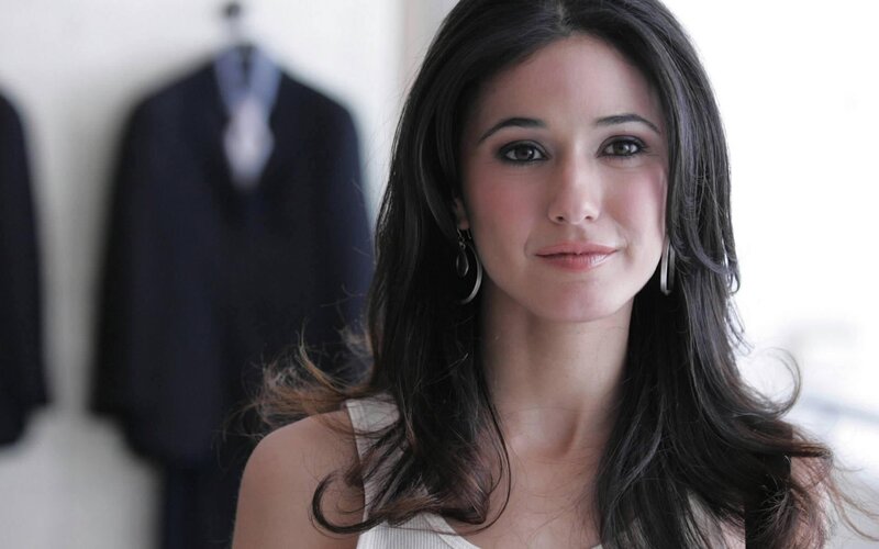 woman with dark hair in front of suits