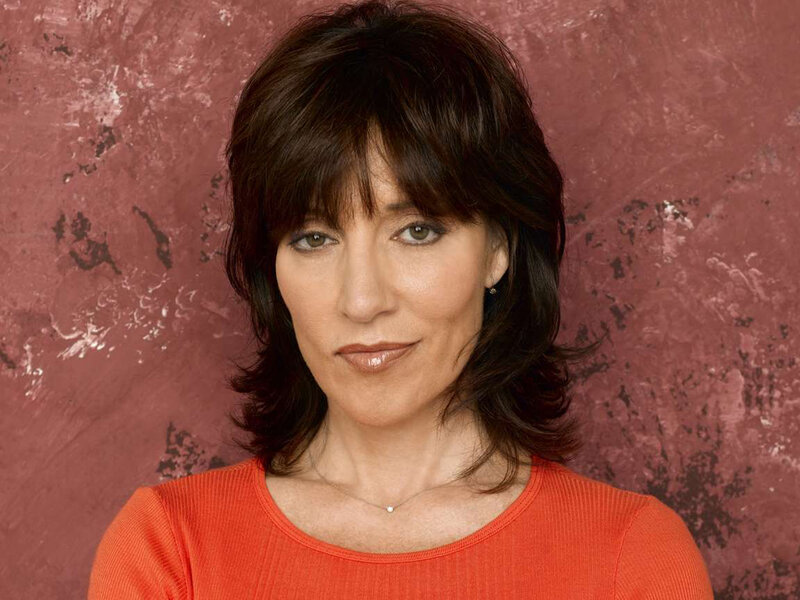 woman with dark hair in orange top