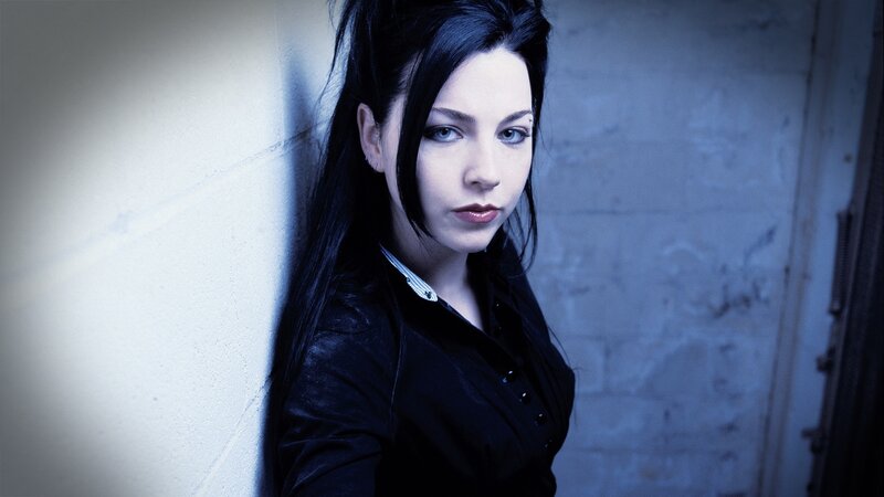 woman with dark hair leaning against wall