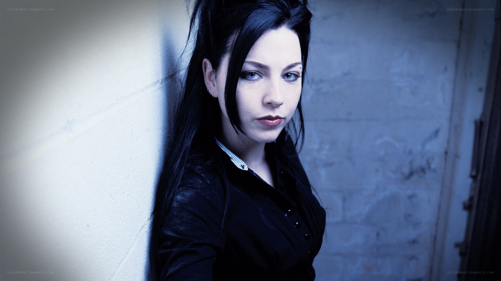 woman with dark hair leaning against wall