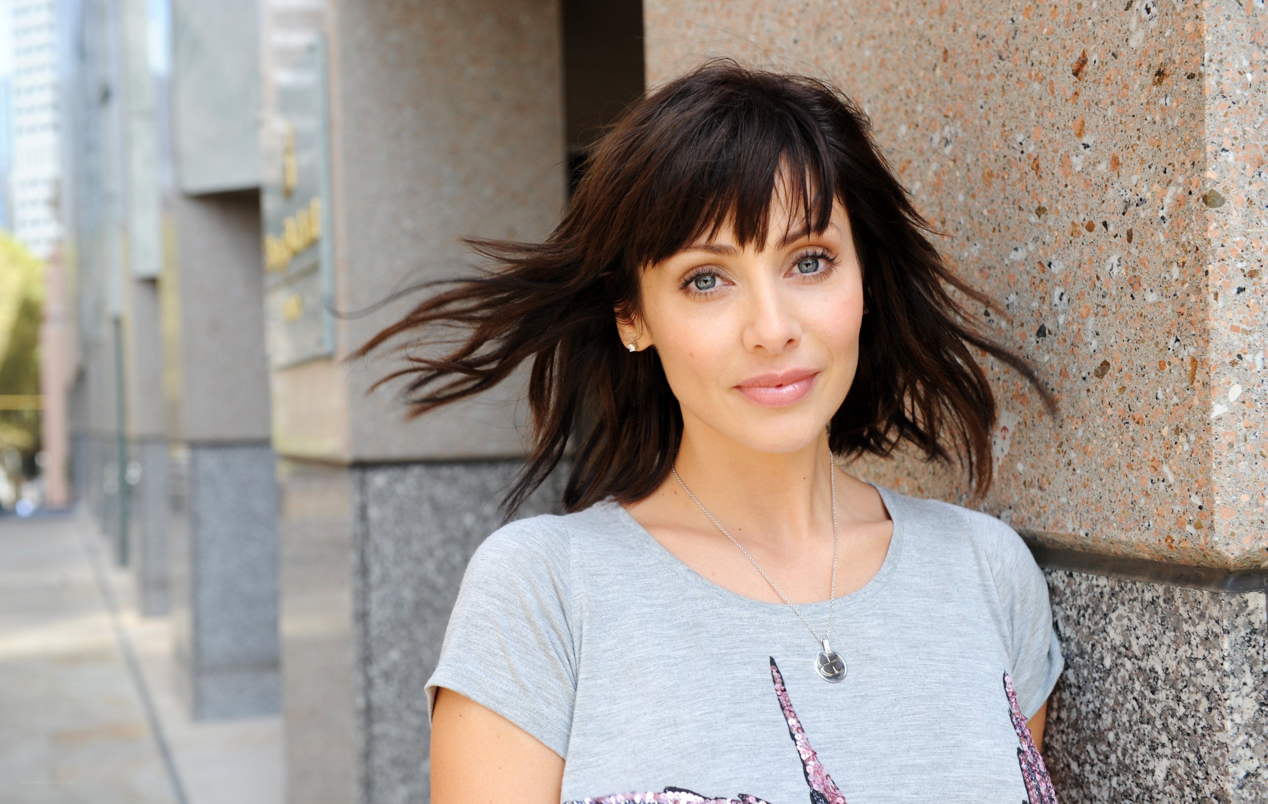 woman with dark hair leaning on wall
