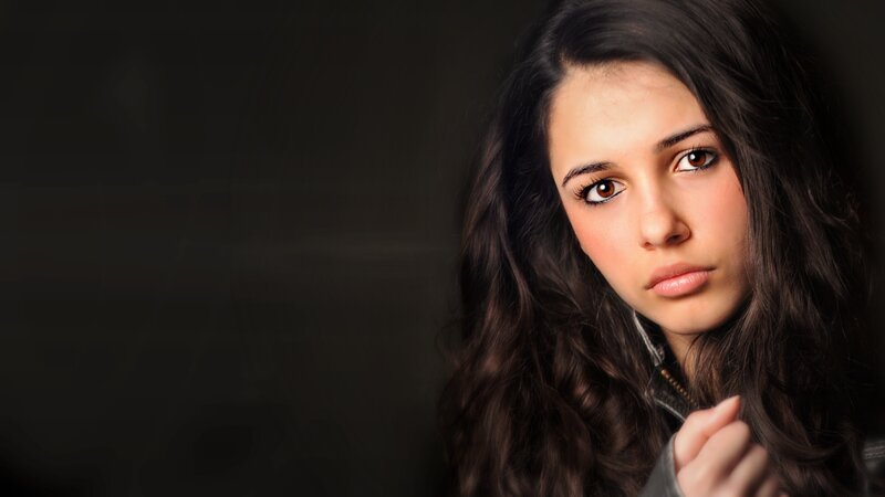 woman with dark hair looking at camera