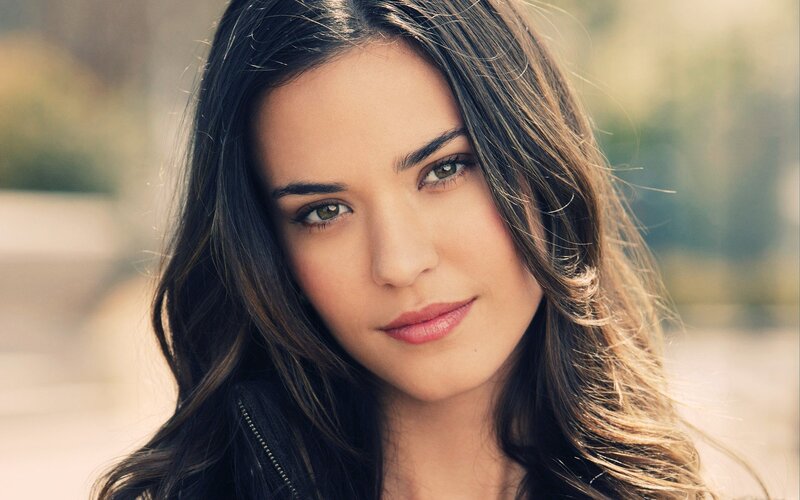 woman with dark hair looking at camera