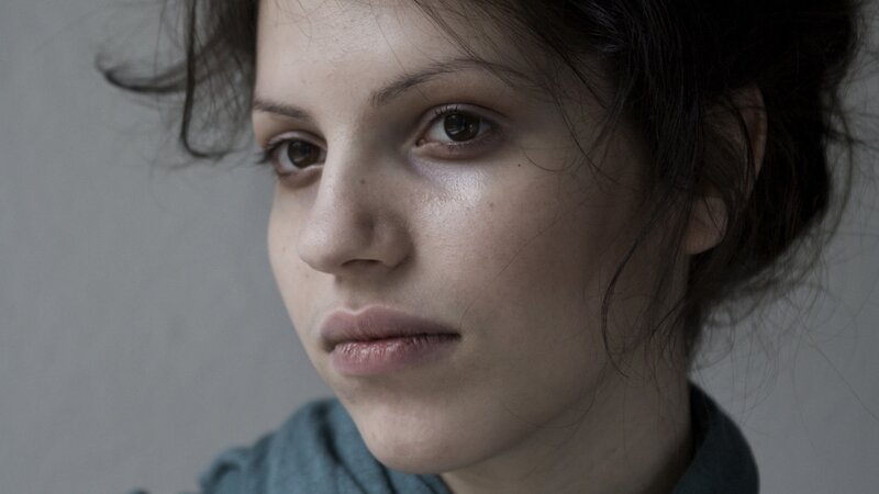 woman with dark hair looking away