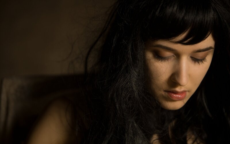woman with dark hair looking down