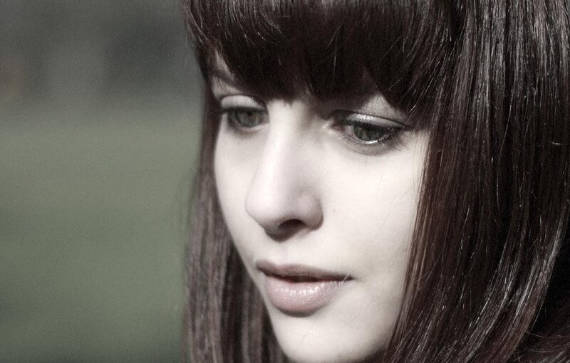 woman with dark hair looking down