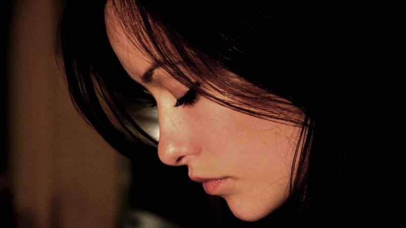 woman with dark hair looking down