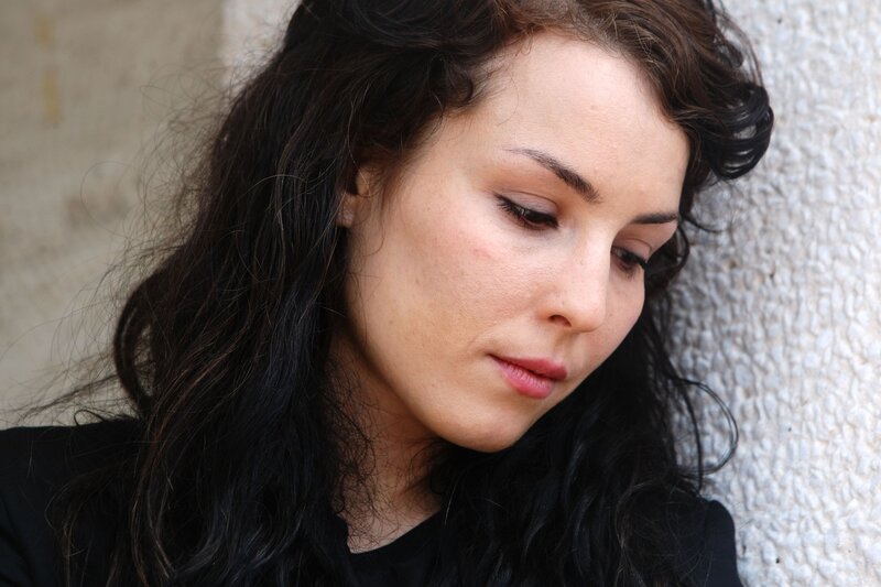 woman with dark hair looking down
