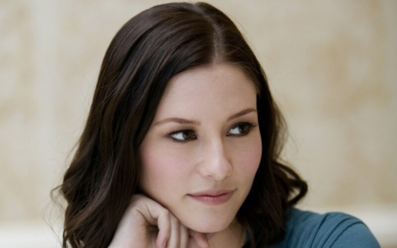 woman with dark hair looking thoughtfully