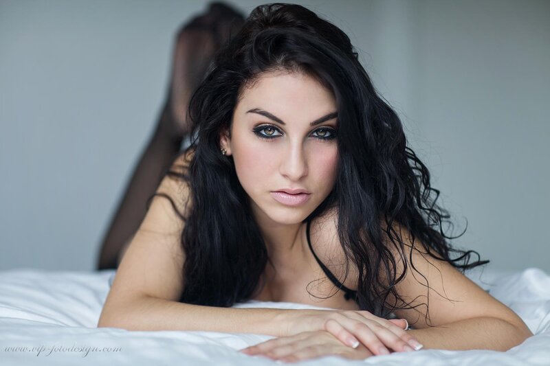 woman with dark hair lying on bed