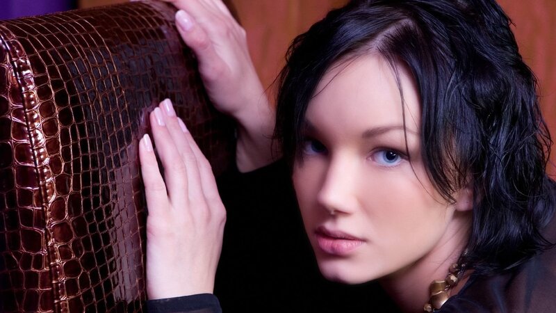 woman with dark hair on leather chair